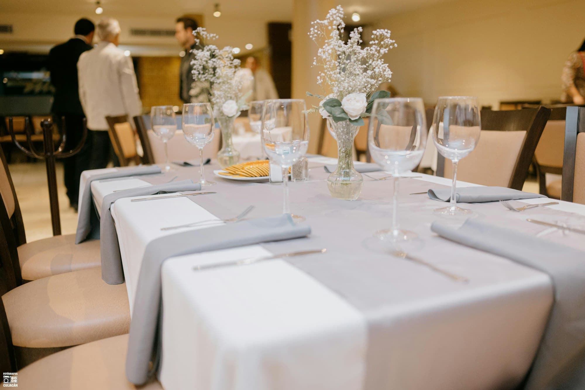 Table d’événement dressée avec vaisselle haut de gamme prête à accueillir les invités